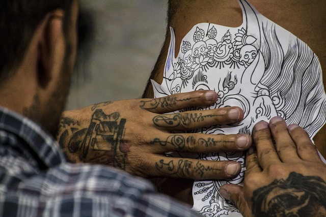 tattoo artist preparing stencil and checking placement in mirror