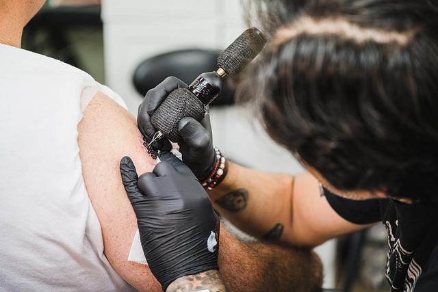 tattoo artist preparing stencil and workstation with sterile supplies